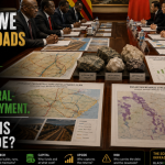 Zimbabwean and Chinese delegations discuss mineral-backed infrastructure financing with railway plans, lithium samples, maps, and revenue charts on the table.